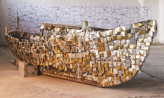 Το έργο “Pledges for a safe passage” (2012) που παρουσιάζεται εδώ με την άδεια της δημιουργού του Kalliopi Lemos (http://kalliopilemos.com) μάς μεταφέρει στην προσπάθεια φοβισμένων ανθρώπων να περάσουν με ασφάλεια τη θάλασσα και να φτάσουν στις ακτές μας. Το έργο βρίσκεται μόνiμα εκτεθιμένο στα Δαρδανέλλια (Canacalle) της Τουρκίας, όπου είχε πρωτοπαρουσιαστεί το 2012 στη Bienalle Canacale. Αποτελείται από ένα αυθεντικό ξύλινο τούρκικο καΐκι που έχει μήκος 6 μ., το οποίο έχει καλυφθεί από την Καλλιόπη Λεμού με χειροποίητα αναθήματα / αφιερώματα/τάματα, καθώς και με μερικά παλιά εκκλησιαστικά τάματα και χέρια hamsa. Σε κάθε αφιέρωμα είναι αναγραμμένο το πρώτο όνομα, η ημερομηνία γέννησης και ο τόπος προέλευσης προσφύγων που πέρασαν τη θάλασσα. 
Το επιλέξαμε για την αρχική σελίδα του Εργαστηρίου μας, αφού -με τα λόγια της Καλλιόπης Λεμού- τόσο το Εργαστήριο όσο και η βάρκα στο έργο “χωράνε τόσους λαούς και γλώσσες”.
Το εργαστήριο μας είναι για αυτούς τους ανθρώπους ένα ασφαλές λιμάνι, και η διδασκαλία της ελληνικής γλώσσας ένα εφόδιο επιβίωσης και εξέλιξης.
Ευχαριστούμε, Καλλιόπη Λεμού,  για την αγάπη και τη γενναιοδωρία
